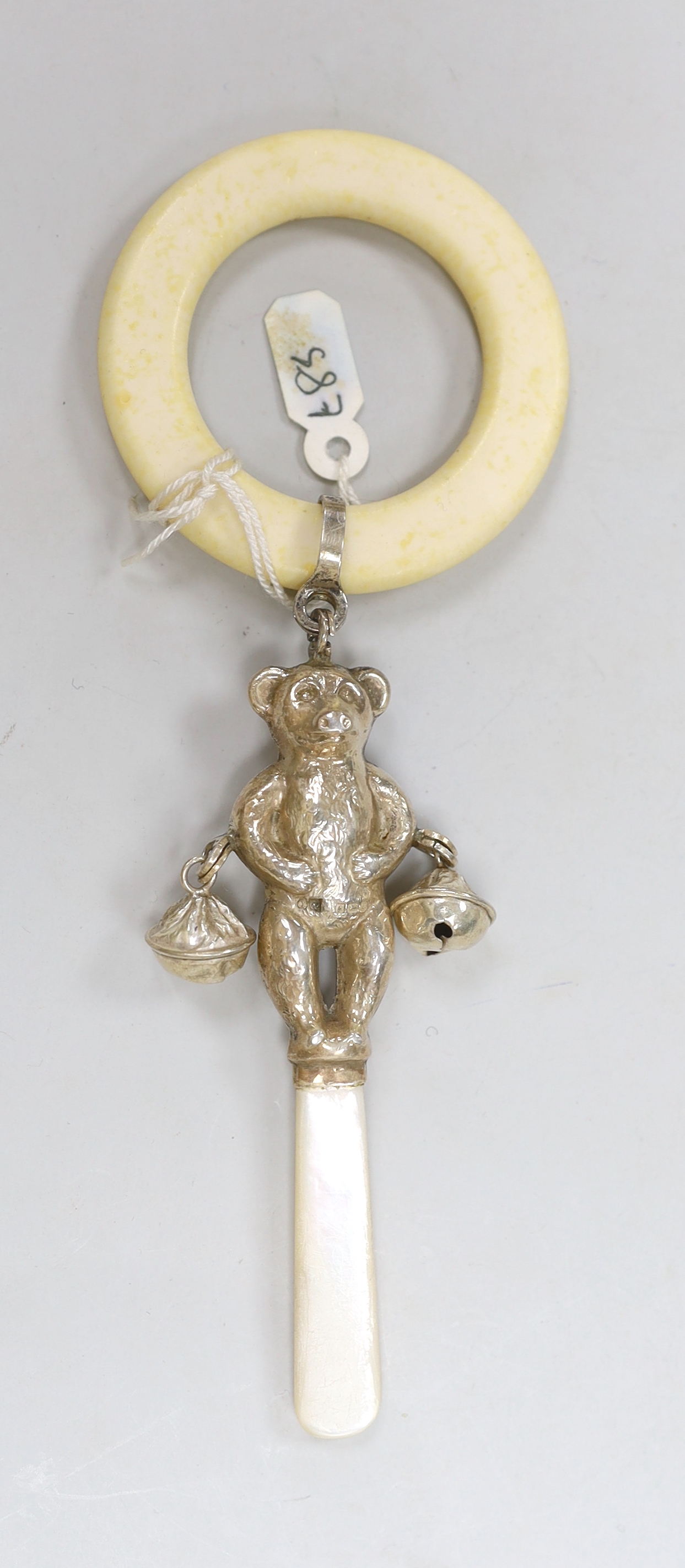 Two Edwardian hat pins with silver hallmarked teddy bea tops, and a silver 1960's teddy bear rattle